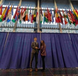 国務省内の日本国旗（右：国務省国際訪問者局担当官、左：野村上席研究員）